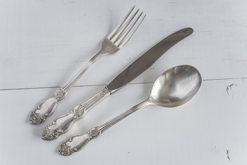 silverware on white wooden background top view