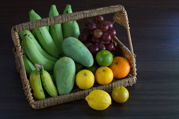 Pile of Thai fresh vegetable on wooden table in dim light kitchen