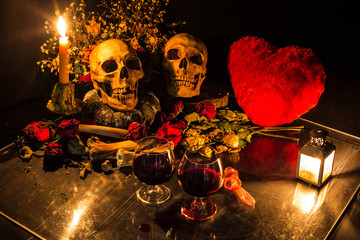 Two skulls, with bone and dry flowers in valentines night