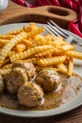 Meatballs with french fries in dill sauce.