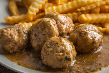 Meatballs with french fries in dill sauce.