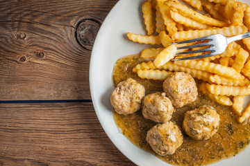 Meatballs with french fries in dill sauce.