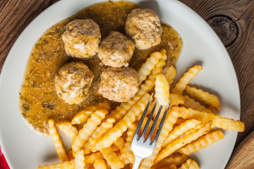 Meatballs with french fries in dill sauce.
