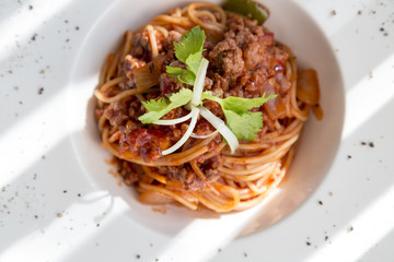 spaghetti tomato sauce with beef and pork in white deep plate