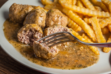 Meatballs with french fries in dill sauce.