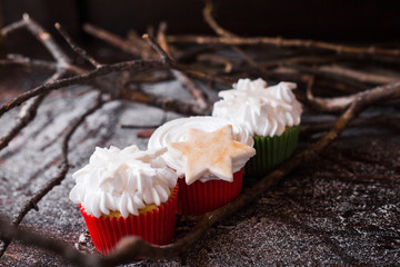 Chocolate cupcakes with white butter cream, decorated withstarson a dark wooden background.