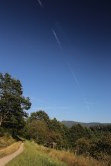 Beautiful landscape in Baden-Wurttemberg with diagonal vapor trail on blue sky