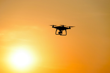Quadrocopters silhouette against the background of the sunset