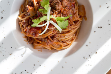 spaghetti tomato sauce with beef and pork in white deep plate
