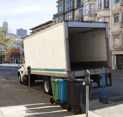 Rear and side view of open delivery truck in urban setting.