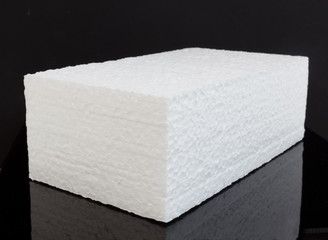 Brick shape white styrofoam block on black background.