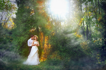 The man and the woman in the wedding dress walking in the autumn Park