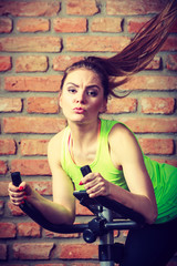 Obraz na płótnie Canvas Active woman using exercise bike at the gym.