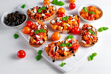 Tasty Traditional Tomato bruschetta with feta cheese topping, fresh basil and balsamic vinegar