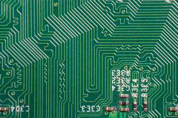 Photo of printed circuit board (PCB) circuit path pattern on electronic device, the circuit path reflection make it look like three dimensional image. The color of the PCB is green