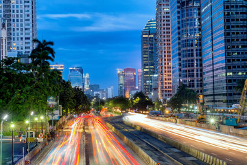 Iconic skyline and light trail of  heavy traffic in Sudirman Street, Jakarta, Indonesia at dusk, showing light trail  of busy traffic and iconic skyscrapers in Jakarta.  Urban Skyline