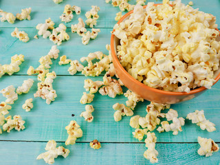 Popcorn in cup on blue background.