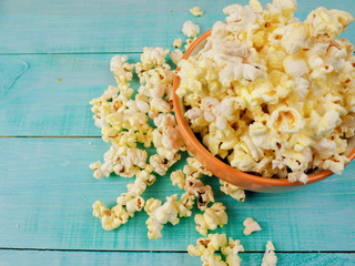 Popcorn in cup on blue background.
