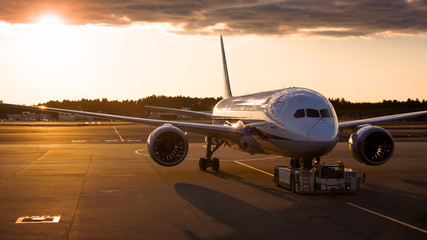 Airplane to runway at sunset