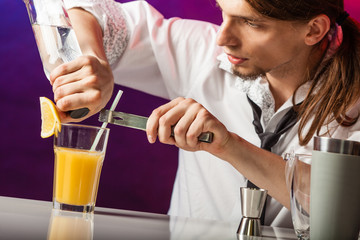 Young bartender pouring beverages.