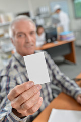 Man holding up his business card