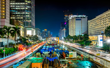 Monorail or mass rapid transit construction at night, in M.H Thamrin Street, Jakarta. Showing beautiful buildings and light trail from busy traffic.  Urban Skyline, Building Exterior, Capital Cities