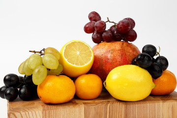 different fruits on a wooden board on a white background