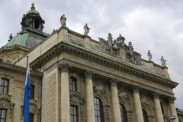 Fototapeta na wymiar Justizpalast (Nordfassade) am Alten Botanischen Garten in München: Mittelrisalit mit Wappen und Figurengruppe