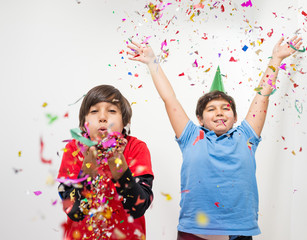 Happy kids celebrating party with blowing confetti