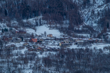 homes in the mountains surrounded by snow-covered trees and fresh snow