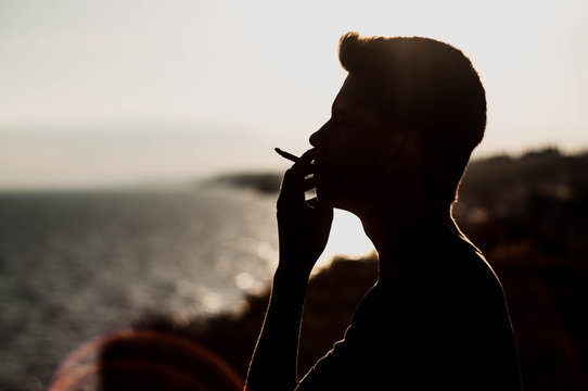 Young Man Smoking Cannabis On The Sea Background