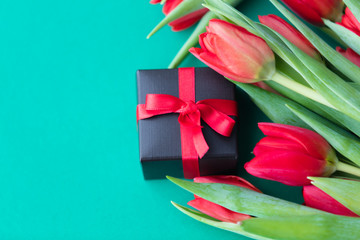 red tulips bouquet and gift box
