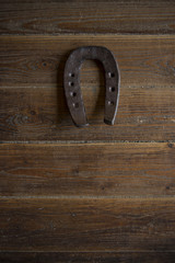 Lucky horse shoe on old retro vintage aged wooden background