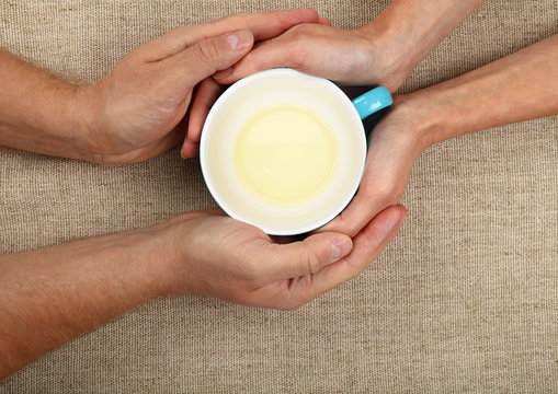 Man and woman hands hold empty green tea cup