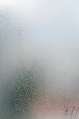 Blurry abstract closeup of foggy condensation on window glass background
