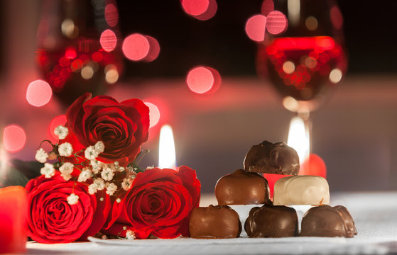 Red roses and chocolates in a romantic date night setting. 