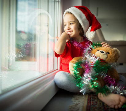 Little boy in red cap of Santa Claus celebrates Christmas