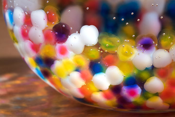 Bright colorful background - balls hydrogel in a glass jug