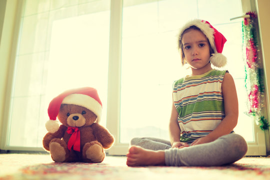Christmas picture little boy in Santa hat with cute teddy bear s