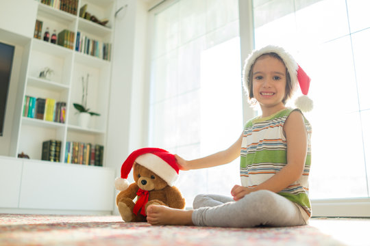 Christmas picture little boy in Santa hat with cute teddy bear s