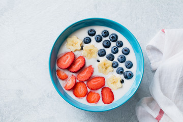 Bowl of natural yogurt with fresh fruits, strawberries, bananas and blueberries. Healthy breakfast, dessert or snack concept. Colors of American flag, Independence day concept.