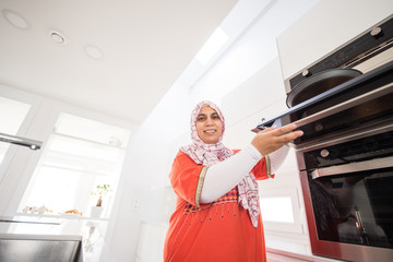 Muslim traditional clothing woman in white modern kitchen