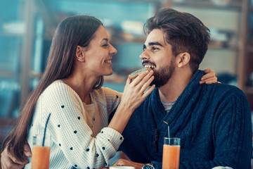 Happy young couple having breakfast in cafe
