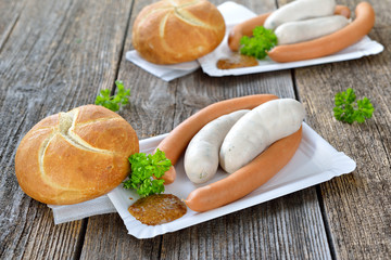 Streetfood bayerisch: Zwei Münchner Weißwürste und ein Paar Wiener mit süßem Senf und Semmel auf Pappteller - Bavarian snack:  Munich white sausages and wieners with a fresh roll and sweet mustard