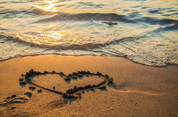 sand heart on the beach at sunset