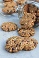 Flourless gluten free peanut butter, oatmeal and chocolate chips cookies in glass jar and on table, vertical