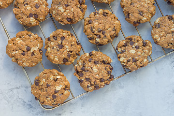 Flourless gluten free peanut butter, oatmeal and chocolate chips cookies on parchment, top view, copy space, horizontal