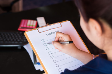 image of businessfemale preparing checklist at office desk