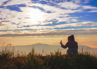 Woman sitting on the log and taking photos on the mountain, Vintage Tone..