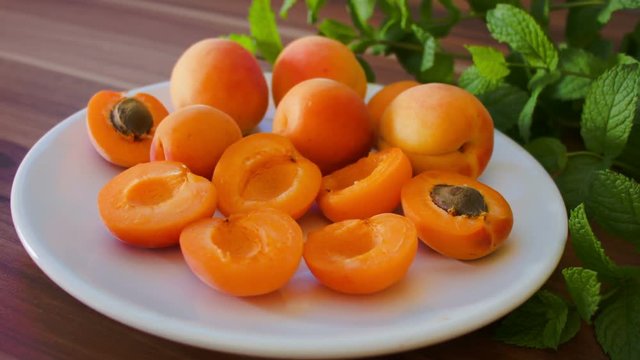 Ripe tasty apricot on a white plate on the table
